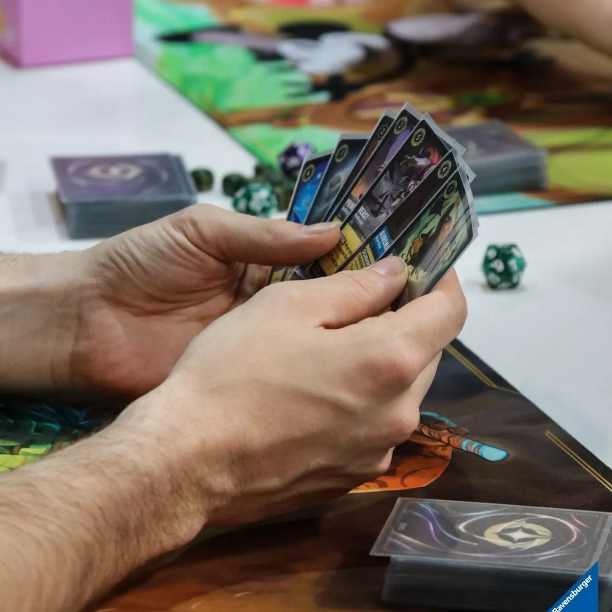 Organised Play Een hand die Disney Lorcana kaarten vasthoudt en deze ruilkaarten speelt