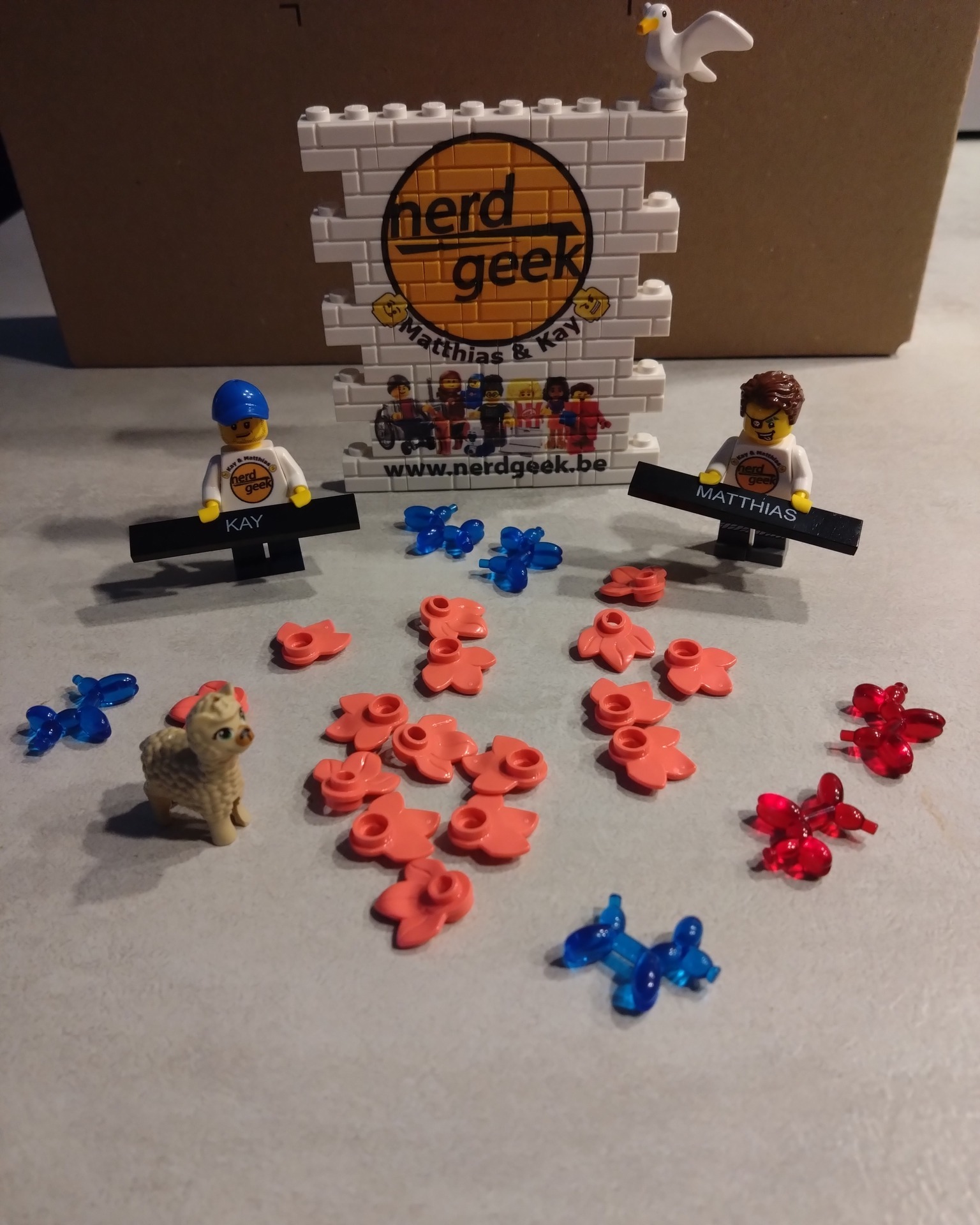 Laten we elkaar Samen ontmoeten Twee LEGO minifiguren omringd door bloemen, een geit en een muur met nerdgeek graffiti erop
