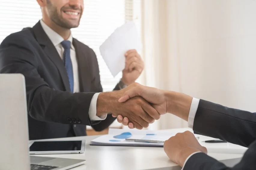 Verkoop op commissie Twee personen die elkaar de hand schudden om te concluderen dat ze elkaar begrijpen en overeenkomen